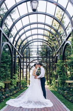 Genç çift parkta kemerleriyle poz veriyor.     