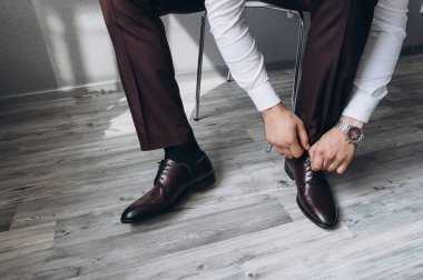 Deri ayakkabı giyen zarif bir adamın kırpılmış fotoğrafı.