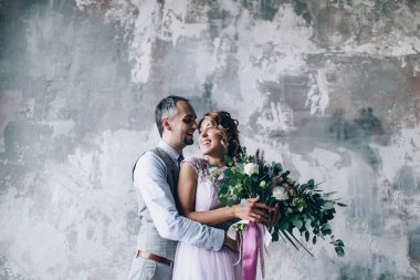 Stüdyoda birlikte poz veren mutlu, genç bir çift.       