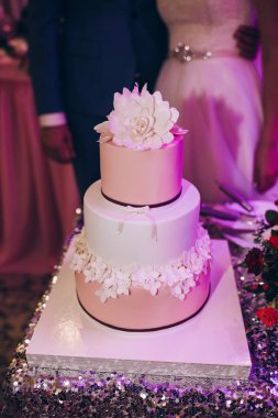 Beyaz ve pembe çiçekli lezzetli düğün pastası.