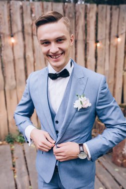 Takım elbiseli yakışıklı damat gülümsüyor 