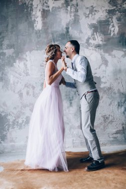 Stüdyoda birlikte poz veren mutlu, genç bir çift.       