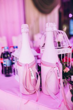 Arka planda çiçekler ve şampanya şişeleriyle düğün masası.