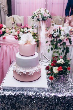 Çiçekli arkaplanda nefis düğün pastası. 