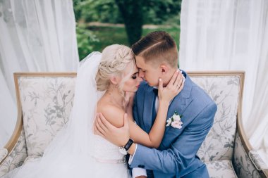 Güzel genç gelin ve damat düğün günü birlikte oturup sarılıyorlar..             