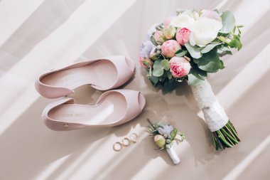 Zarif düğün ayakkabıları ve güzel çiçeklerin yakın çekimi.            