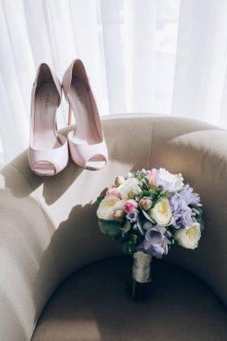 Zarif düğün ayakkabıları ve güzel çiçeklerin yakın çekimi.            