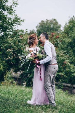 Parkta kucaklaşan mutlu genç bir çiftin portresi.                