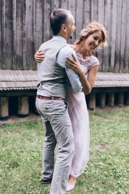 Mutlu genç gelin ve damat düğün günü dışarıda eğleniyor ve gülüyorlar.            