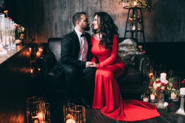 Güzel, zarif, aşık bir çift. Lüks bir iç mekanda, kanepede oturuyor..           