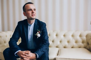 Takım elbiseli yakışıklı genç damadın portresi.         