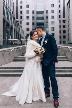 Güzel, mutlu bir düğün çifti şehirde poz veriyor.