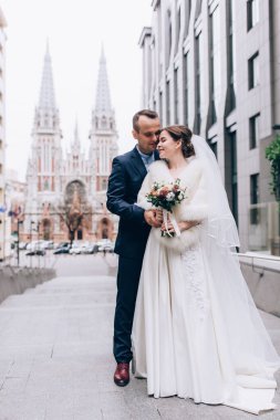 Güzel, mutlu bir düğün çifti şehirde poz veriyor.