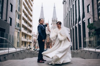 Güzel, mutlu bir düğün çifti şehirde poz veriyor.