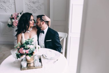 Zarif servis masasında oturan genç ve güzel bir çift.       