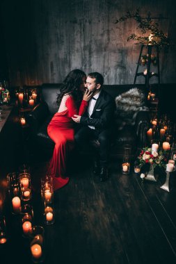 Güzel, zarif, aşık bir çift. Lüks bir iç mekanda, kanepede oturuyor..           