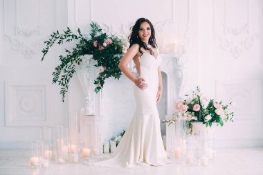 Beyaz elbiseli güzel, genç gelin zarif iç çamaşırlarıyla poz veriyor.       