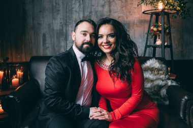 Güzel, zarif, aşık bir çift. Lüks bir iç mekanda, kanepede oturuyor..           