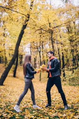 Genç çift sonbahar parkında poz veriyor.