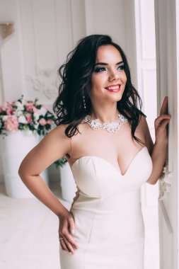 Beyaz elbiseli güzel, genç gelin zarif iç çamaşırlarıyla poz veriyor.       