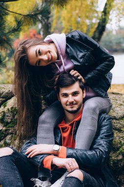 Genç çift sonbahar parkında poz veriyor.