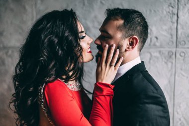 Stüdyoda sarılıp öpüşen zarif genç bir çift..