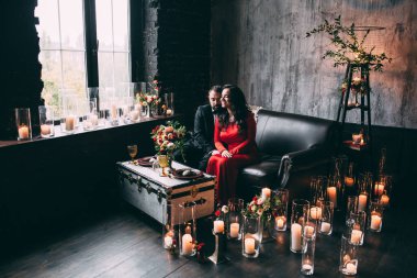 Güzel, zarif, aşık bir çift. Lüks bir iç mekanda, kanepede oturuyor..           