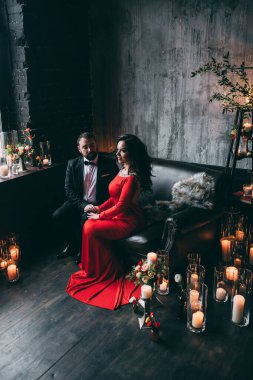 Güzel, zarif, aşık bir çift. Lüks bir iç mekanda, kanepede oturuyor..           