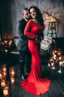 Şatafatlı bir iç mekanda mumları olan zarif genç bir çift.              