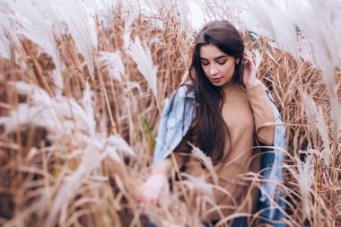 Genç bir kadının sonbahar baston tarlasında portresi.