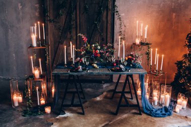 Çiçeklerle, mumlarla ve Noel ağacıyla süslenmiş servis masası. 