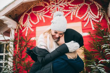 Genç çift, şehirdeki Noel süslerinde kışlık kıyafetler giyiyor. Yeni yılın aşk hikayesi.. 