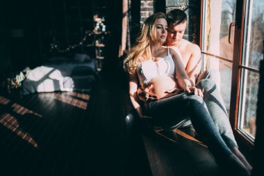 Pencerenin kenarında oturan genç ve güzel bir kadın 