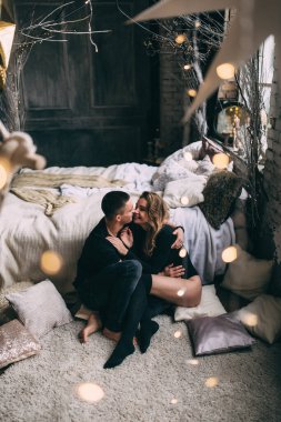 Genç çift yatak odasının yanında öpüşüyor.