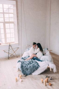 Stüdyoda poz veren mutlu genç çift Noel için süslendi. 