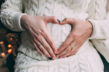 Kadın elleri göbeğini gösteriyor. 