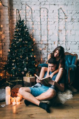 Noel arifesinde kitap okuyan aşıklar.       