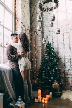 Güzel, genç ve aşık bir çift. Sıcak bir Noel 'de kucaklaşıyorlar.              