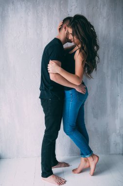 Aşık güzel bir çift duvara karşı poz veriyor. 