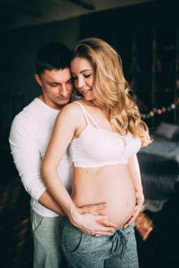 Kocası stüdyo odasında hamile bir kadın.