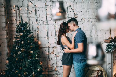 Güzel, genç ve aşık bir çift. Sıcak bir Noel 'de kucaklaşıyorlar.              