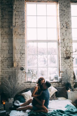 Güzel, genç ve aşık bir çift yatak odasında öpüşüyorlar.               