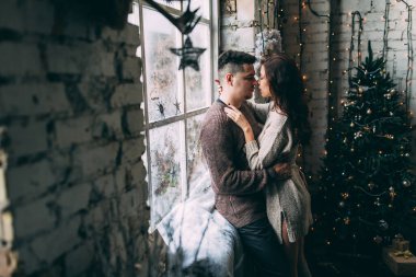 Güzel, genç ve aşık bir çift. Sıcak bir Noel 'de kucaklaşıyorlar.              