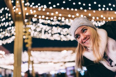 Genç çift, şehirdeki Noel süslerinde kışlık kıyafetler giyiyor. Yeni yılın aşk hikayesi.. 