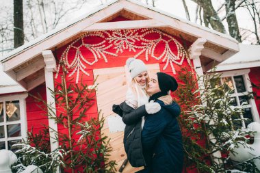 Genç çift, şehirdeki Noel süslerinde kışlık kıyafetler giyiyor. Yeni yılın aşk hikayesi.. 