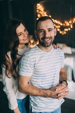 Stüdyonun arka planında birbirini seven mutlu genç çift.