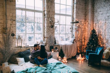 Mutlu aile, dekore edilmiş iç kısımda, stüdyo yatağında uzanıyor. 