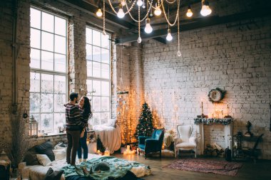 Mutlu adam ve kadın, süslü stüdyo odasında poz veriyorlar.