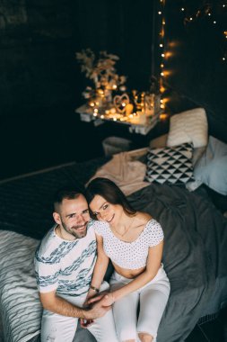 Aşık genç çift stüdyoda bir yatakta yatıyor.