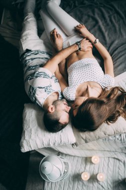 Genç çift, stüdyoda yatakta yalan söylüyor ve sarılıyorlar. 